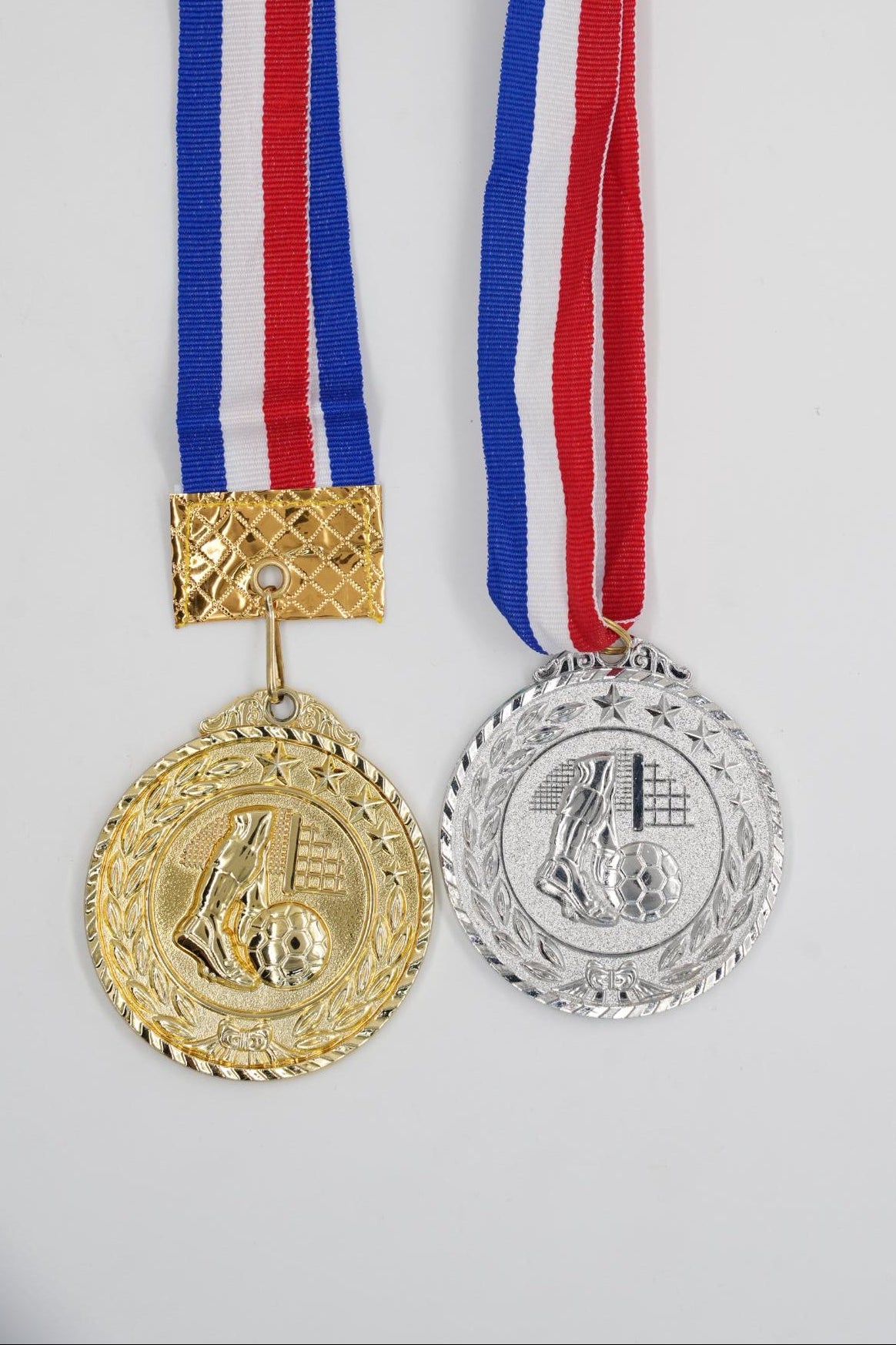 Gold and silver football medals with red white and blue ribbon