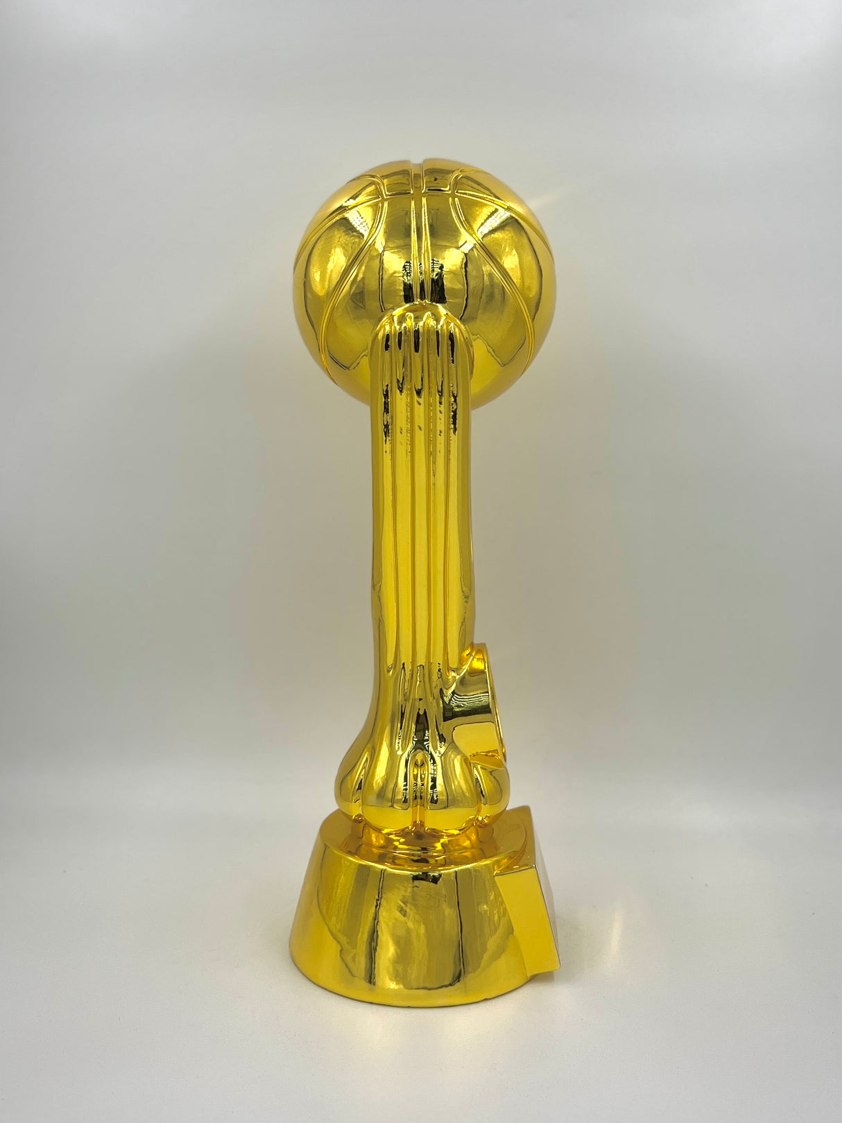 Shiny metallic gold trophy featuring a basketball atop an elegant support column.