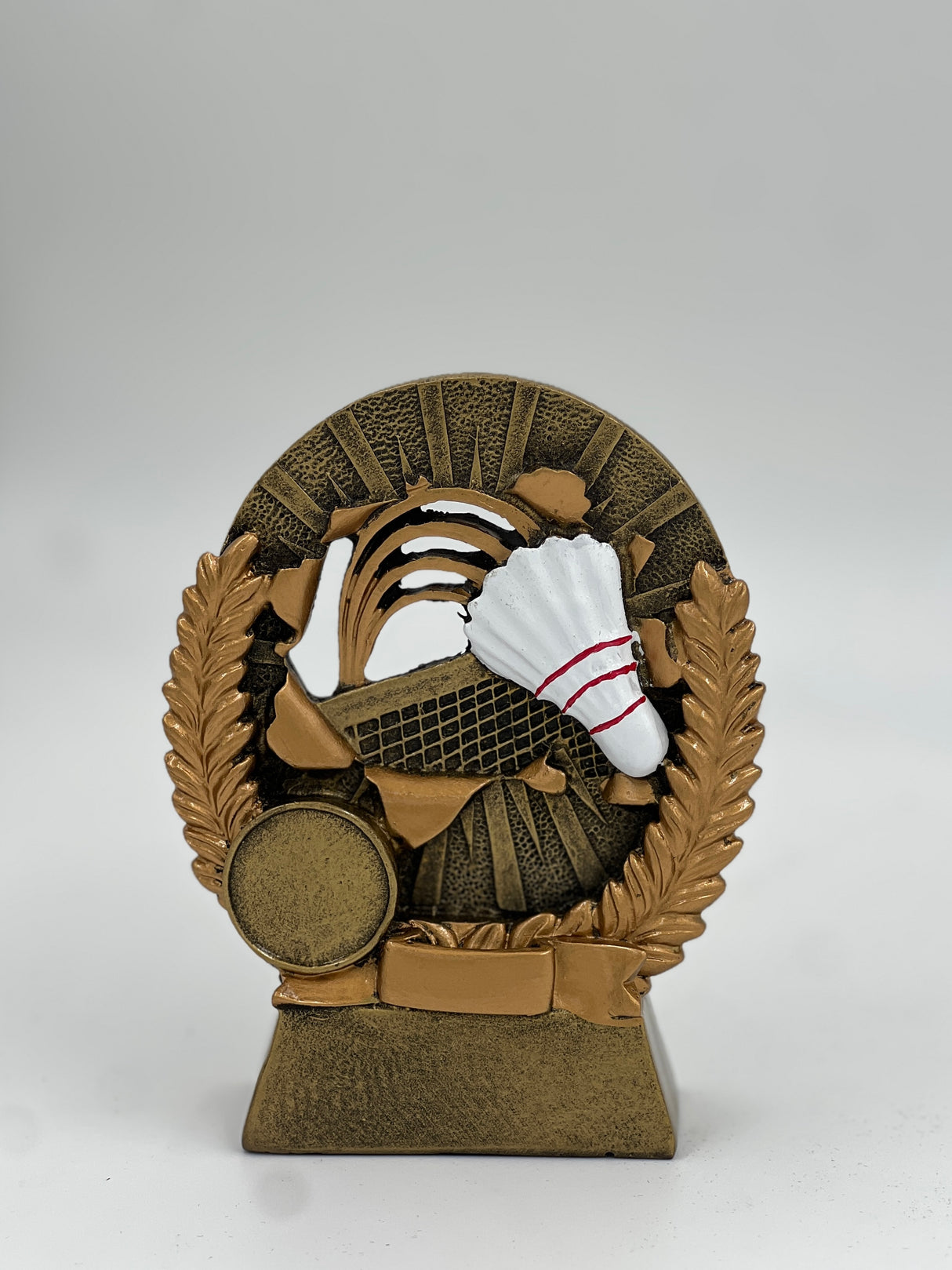 Bronze medallion trophy with racket, shuttlecock, and ball symbols on a black base.