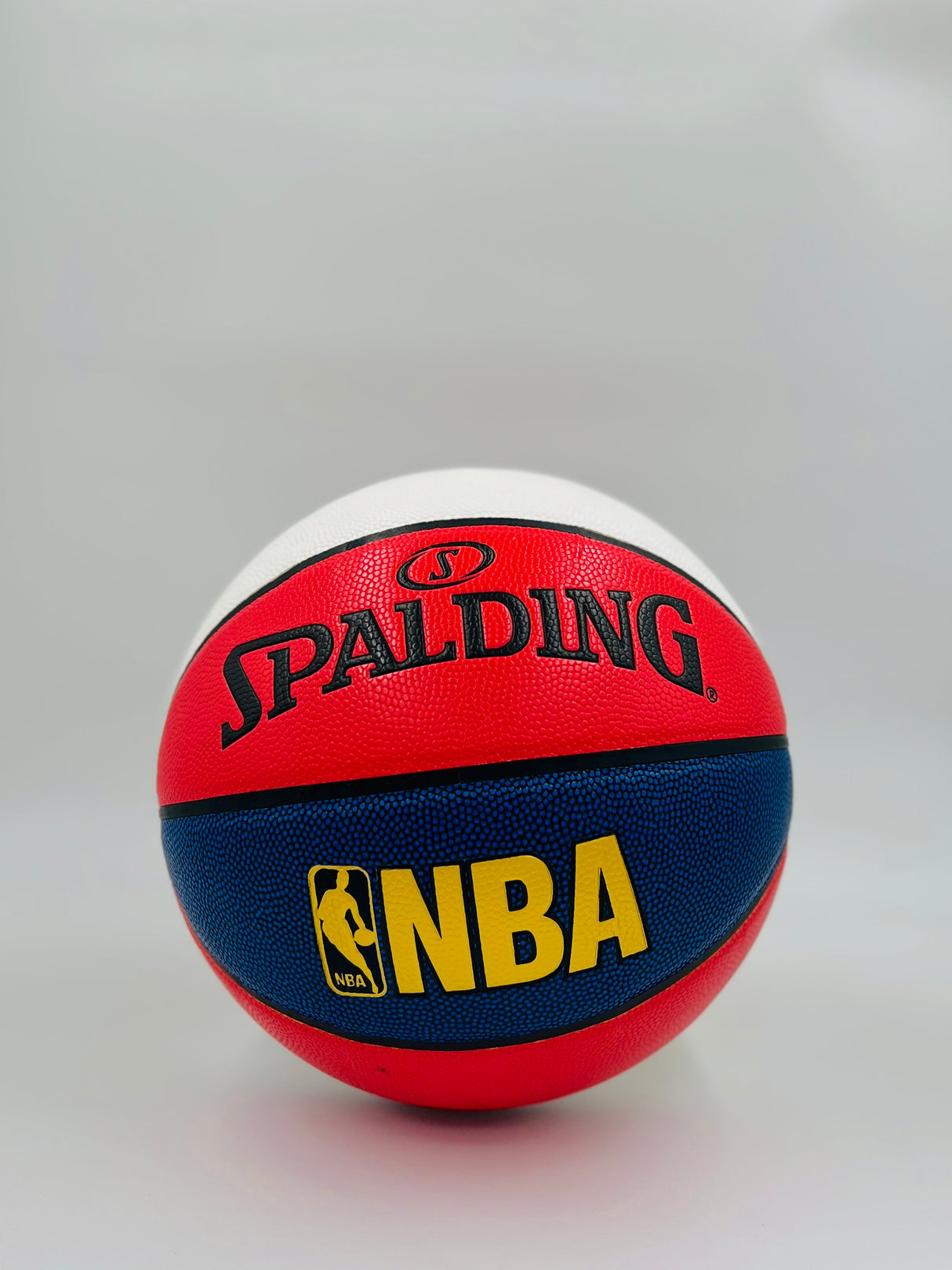 Red, blue, and white Spalding NBA basketball on a light gray background