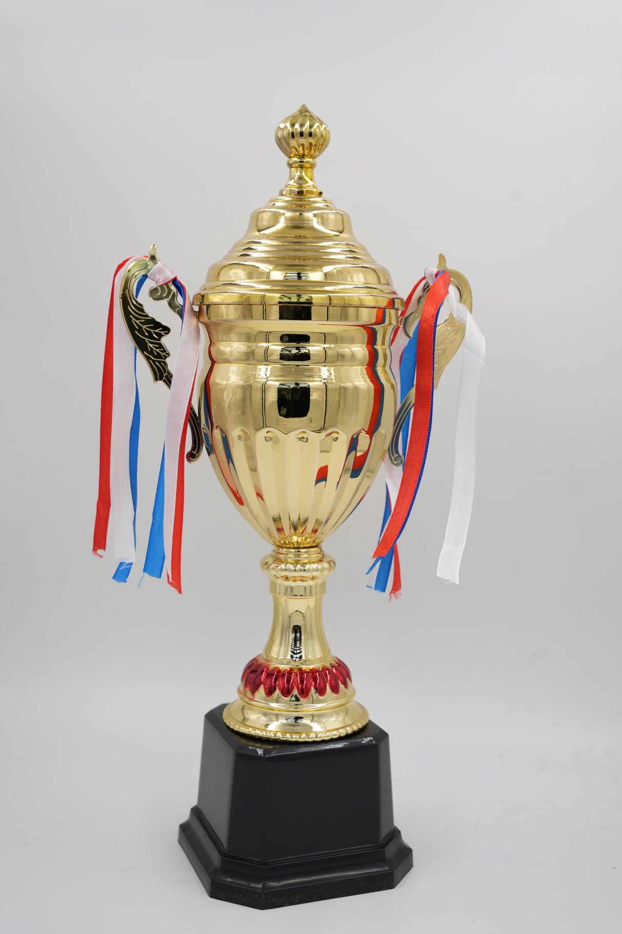 Classic gold winner award cup for tournaments on a black pedestal base