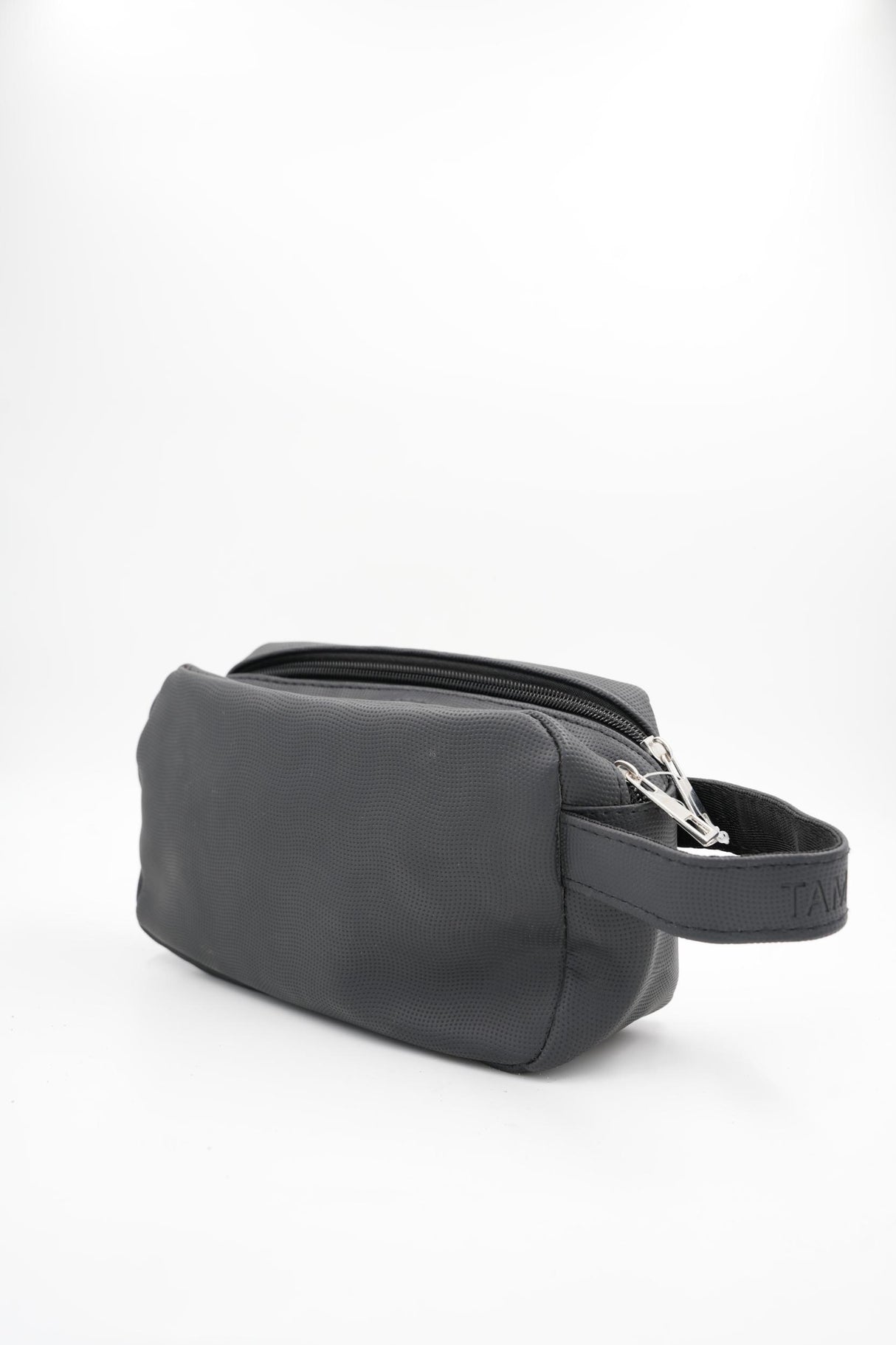 Compact cosmetic or shaving bag in black, side view with handle