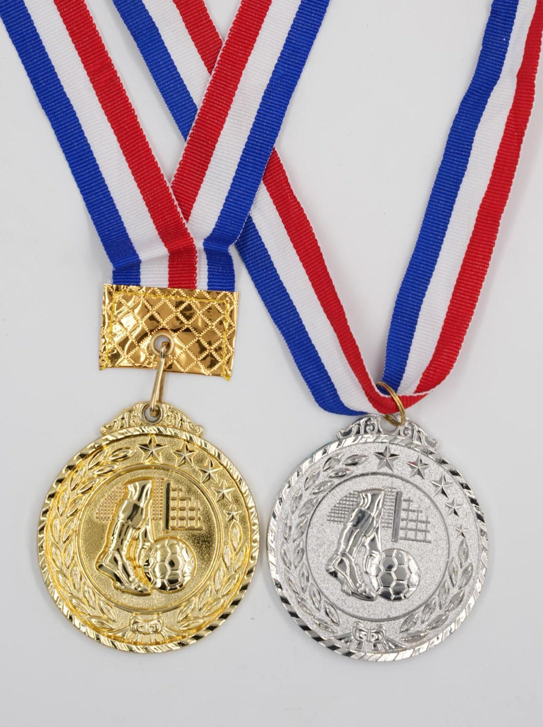 Gold and silver football medals with red white and blue ribbon