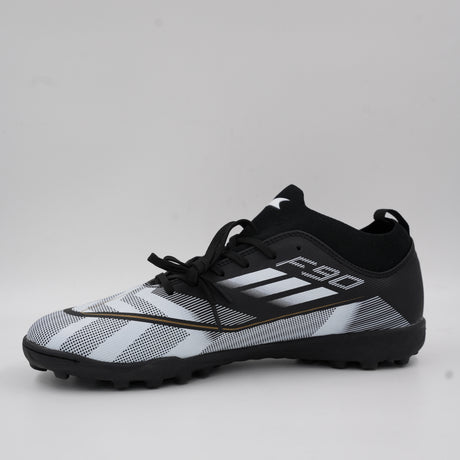 Side view of the F90 men's turf football shoe in black and white, featuring a knitted ankle collar, textured upper for ball control, and a studded rubber sole for artificial grass.