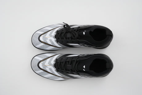 Side view of the F90 men's turf football shoe in black and white, featuring a knitted ankle collar, textured upper for ball control, and a studded rubber sole for artificial grass.
