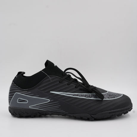 Side view of a black turf football shoe featuring dynamic silver lines, a comfortable knitted ankle collar, and a studded rubber outsole for artificial grass.