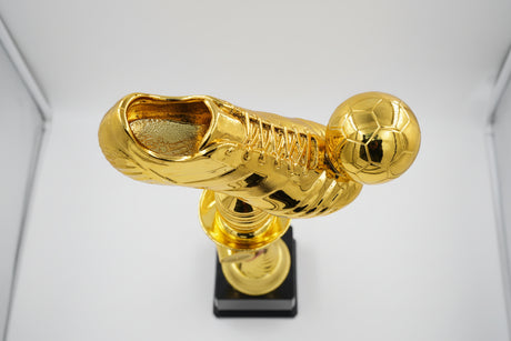 Close-up of the highly detailed golden studded football cleat and soccer ball at the top of the sports trophy.