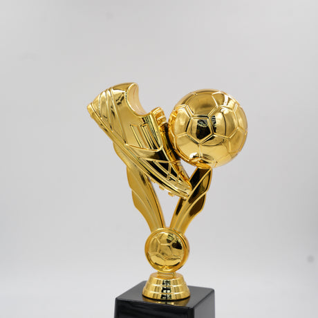 Full view of a bright gold football trophy featuring a soccer shoe kicking a ball, standing on a solid black square base.