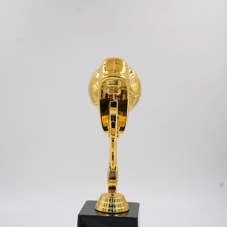 Close-up of the shiny gold soccer cleat and football at the top of the sports champion award.