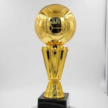 Front view of a premium, highly reflective gold soccer ball trophy resting on a textured gold stem and a solid black square base.