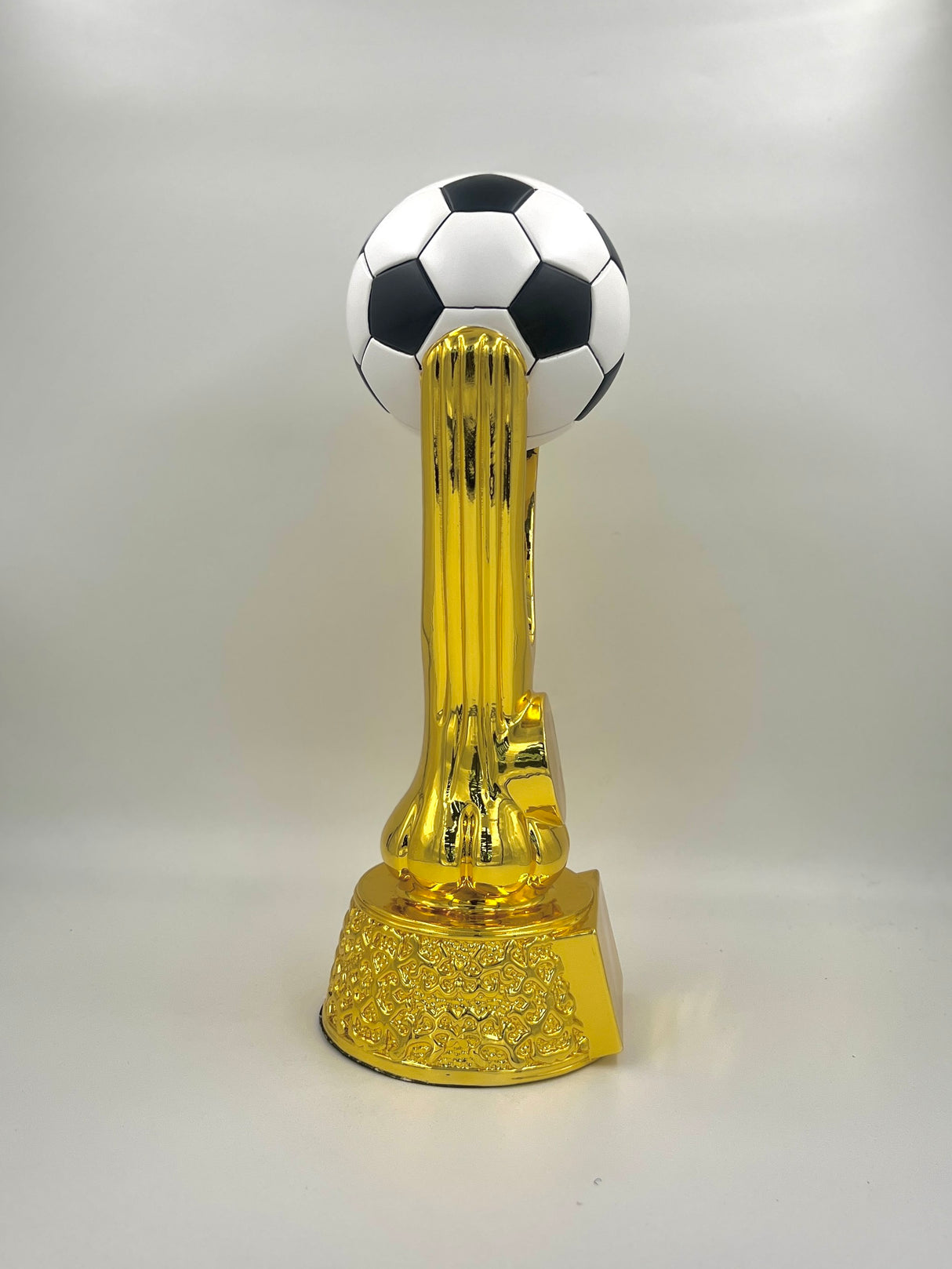 Shiny gold metallic football trophy featuring a classic paneled soccer ball.