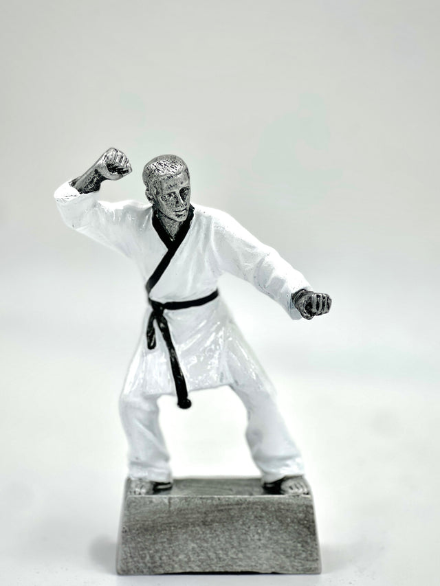 Silver martial arts trophy statue in a fighting pose with a black belt on a gray base.
