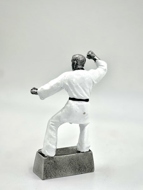 Detailed figure of a Karate or Taekwondo student wearing a white uniform and black belt.