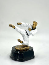 Martial arts trophy statue in a white uniform and black belt executing a high kick.