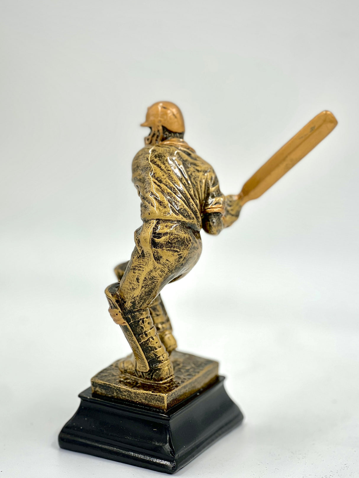 Detailed cricket trophy figure in a batting stance with an antique metallic finish.