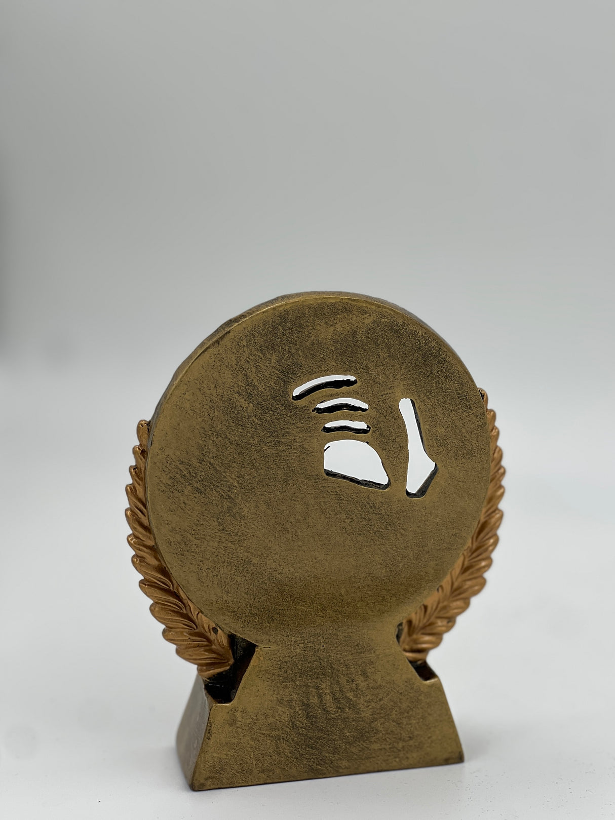 Antique bronze circular trophy depicting racket sports equipment in a detailed relief.