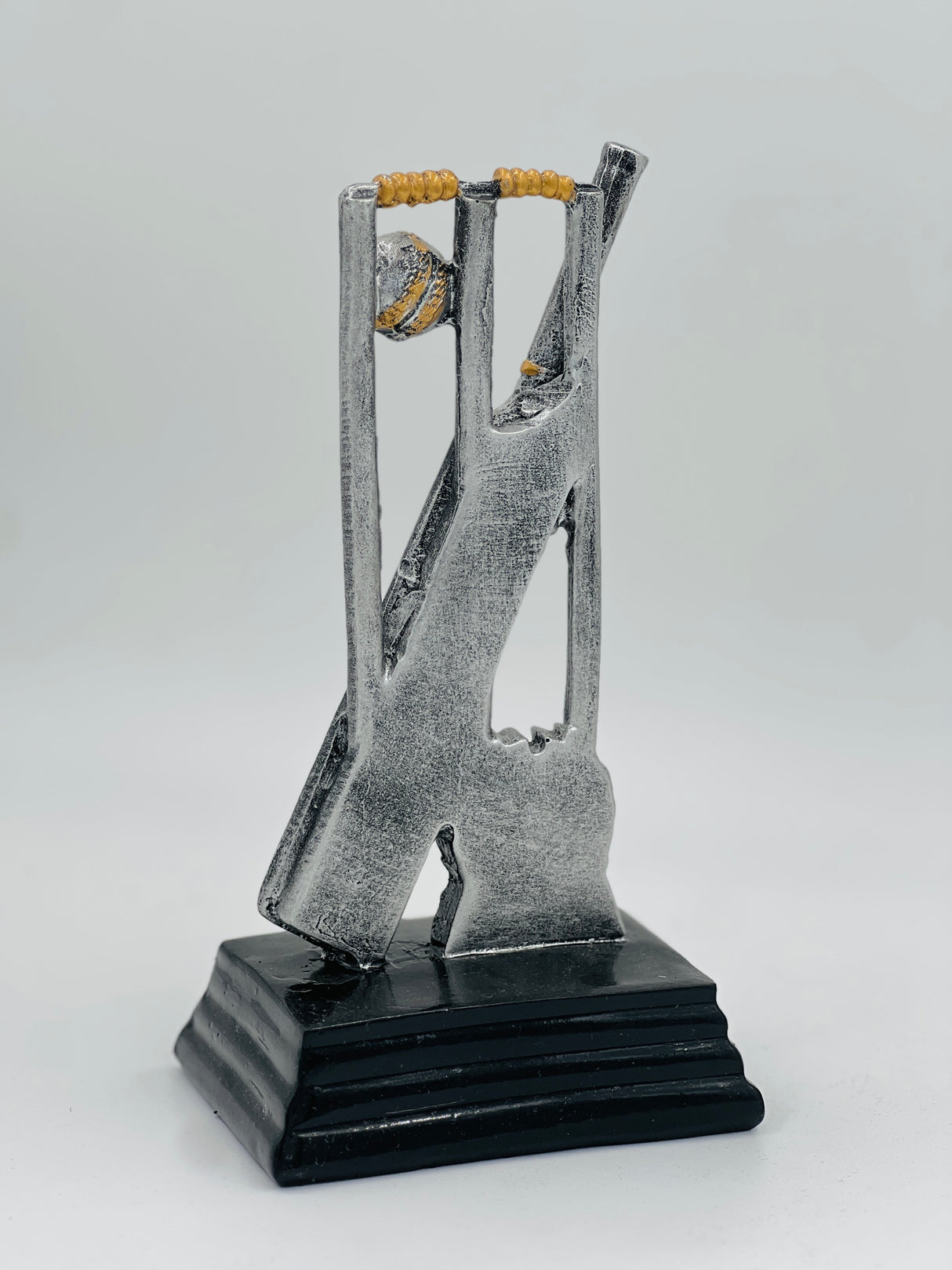 Detailed silver and gold cricket award showcasing stumps, a bat, and a ball, ideal for Man of the Match or league MVP.