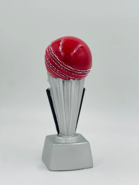 Detailed close-up of a silver-finish sports award featuring a mounted red cricket ball and a clear, flat base for personalization.