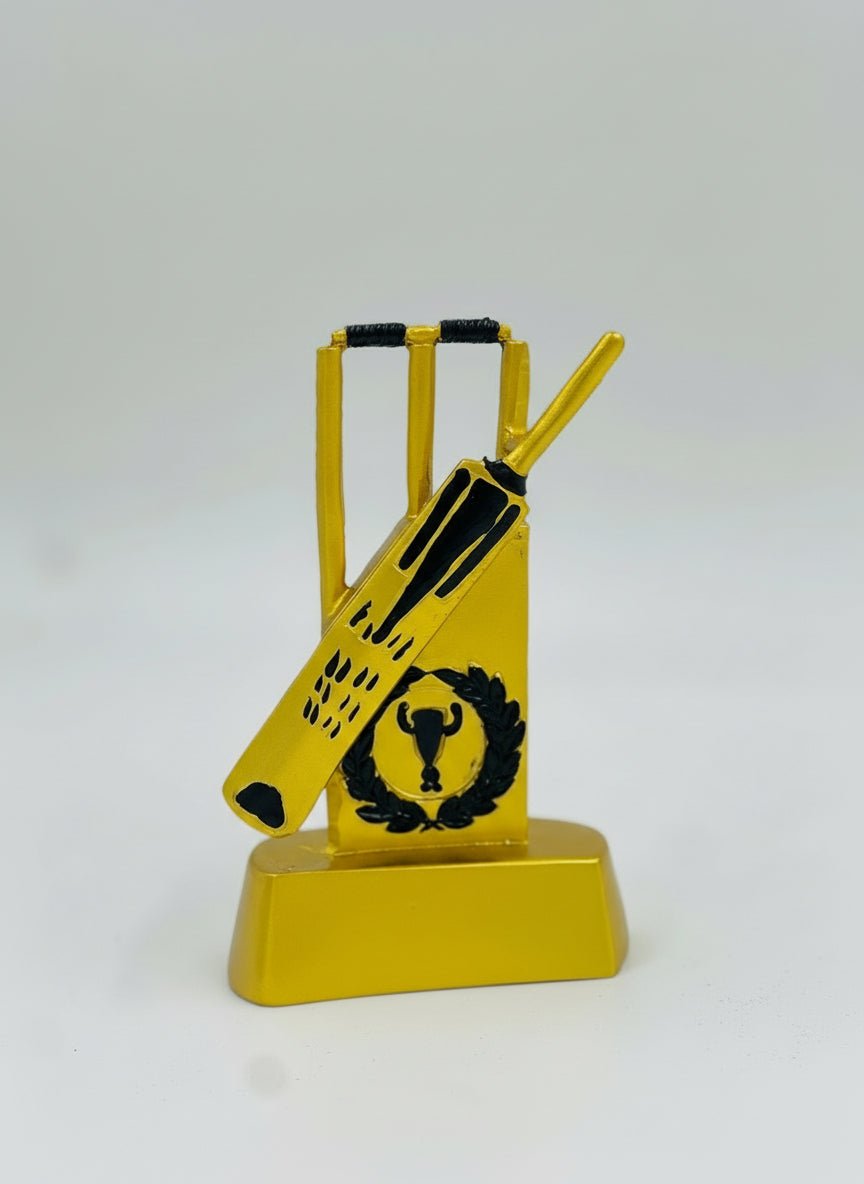 Shiny gold resin cricket trophy featuring detailed bats, stumps, and a central wicketkeeping gloves emblem.