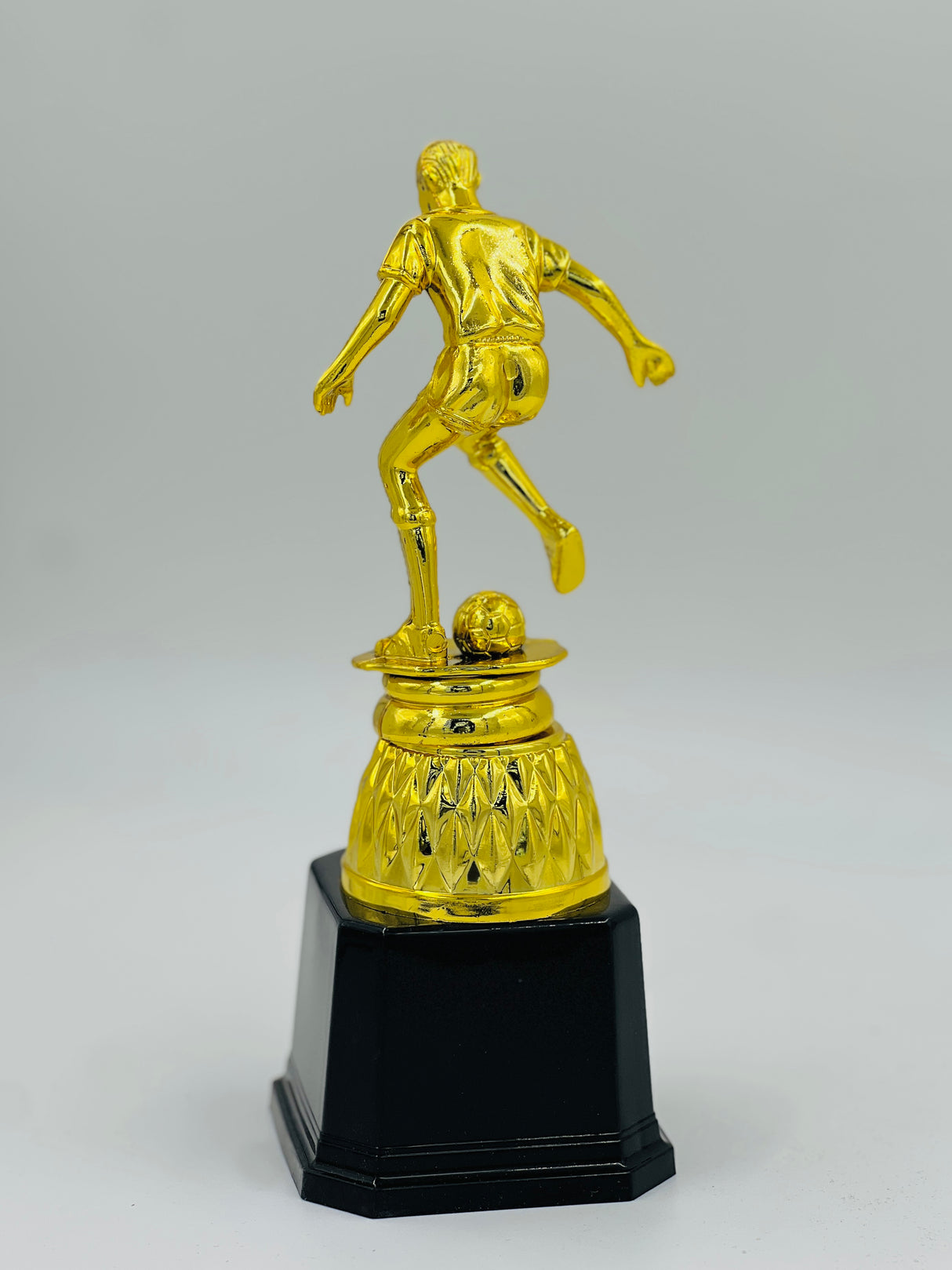 Detailed gold football award figure in a dynamic kicking pose, ideal for league MVP, top goal scorer, or tournament winner recognition.