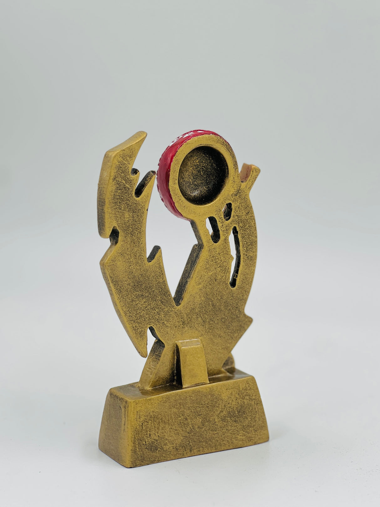 Modern gold resin cricket award with a vibrant red ball centerpiece, ideal for contemporary tournament and club prizes.