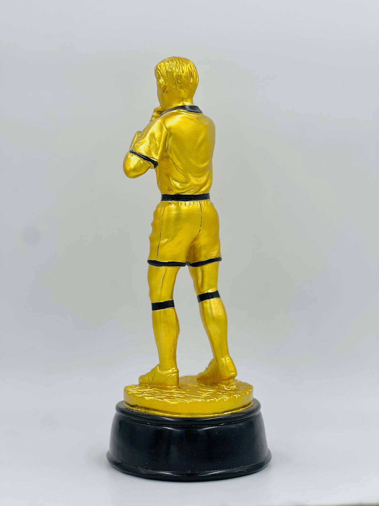 Detailed resin award recognizing a soccer official or referee, painted in yellow and black uniform, standing on a solid black base.