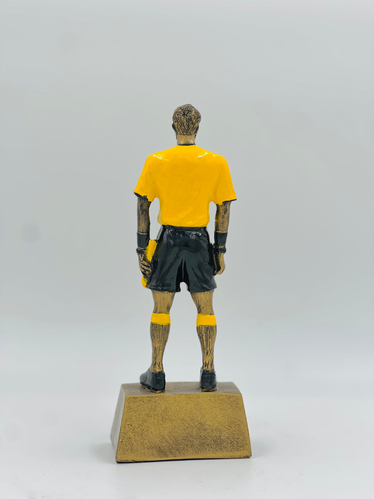 Detailed resin award for football match officials, featuring a referee figure in a standing pose with yellow and black uniform.