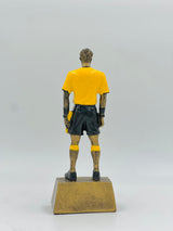 Detailed resin award for football match officials, featuring a referee figure in a standing pose with yellow and black uniform.