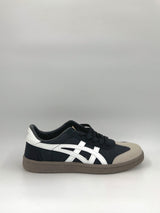 Black and white sneaker with a gray sole on a light gray background