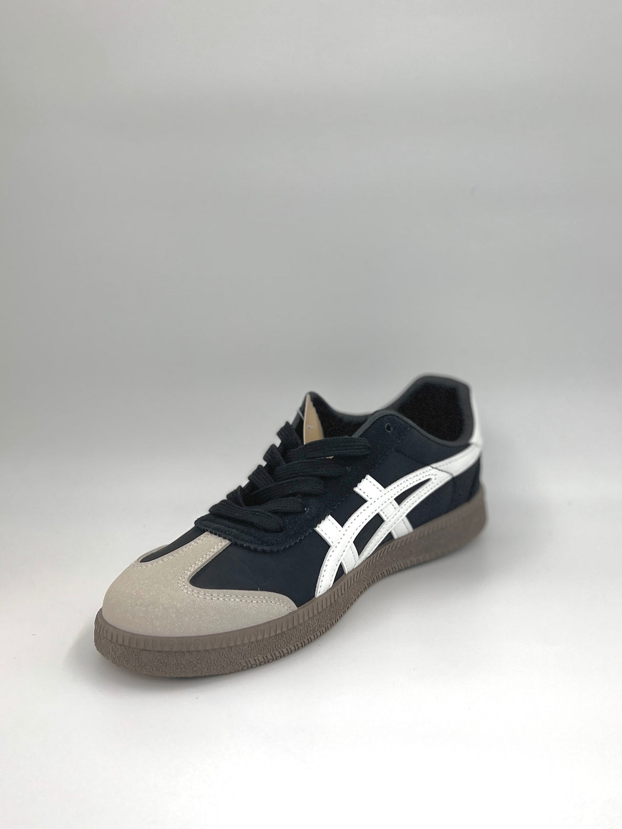 Navy and beige sneaker with white logo on a gray background