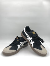 Black and white sneakers with beige accents on a white background